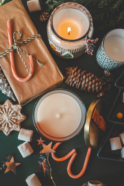 istock Festive Christmas composition with holiday decorations, red cup of tea, candy canes, marshmallows, and gifts on green background 2195619706