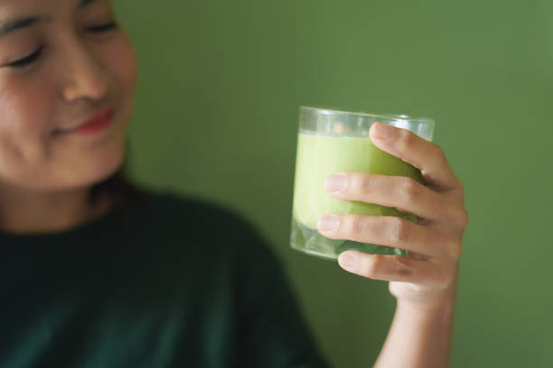 istock Close-up Woman face drinking a vegetable and fruit smoothie 2195621041