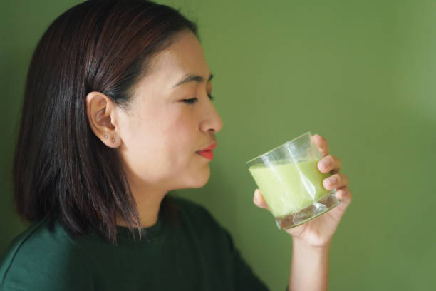 istock Woman is drinking a vegetable and fruit smoothie 2195621042