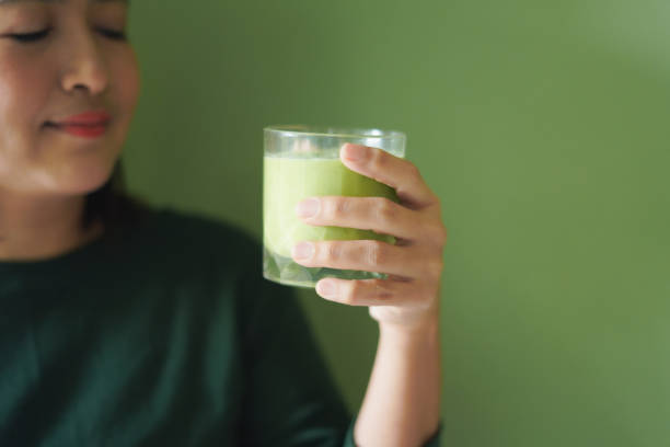 istock Close-up Woman face drinking a vegetable and fruit smoothie 2195621045