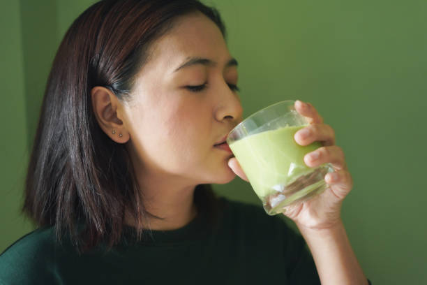 istock Close-up Woman face drinking a vegetable and fruit smoothie 2195621058