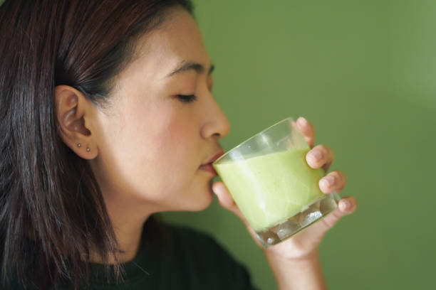 istock Close-up Woman face drinking a vegetable and fruit smoothie 2195621085