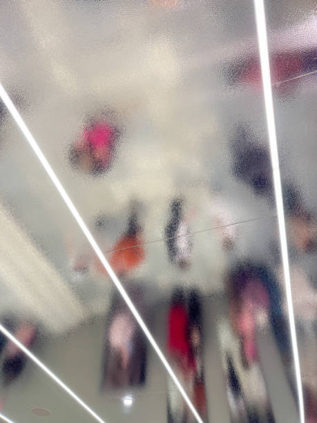 istock A blurry image of people walking in a hallway with a light shining on them 2195621873
