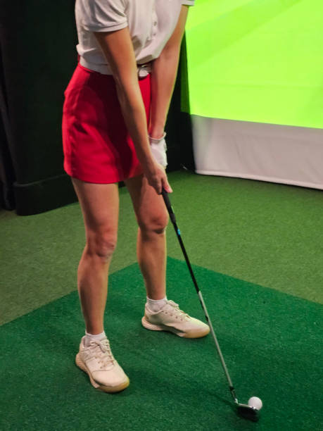 istock A woman practices her golf swing on an indoor driving range concept 2195622338