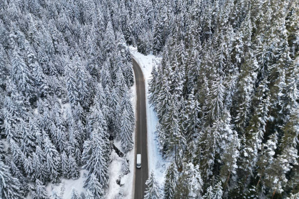 istock Snowy Road with a Car Minibus in the Forest 2195623827