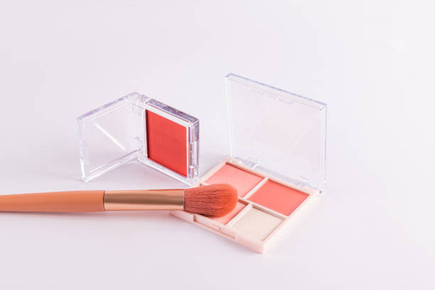 istock Two open packs with peach-tone blush and various light tones on a white background with professional makeup brush. space for text. concept cosmetics. 2195629670
