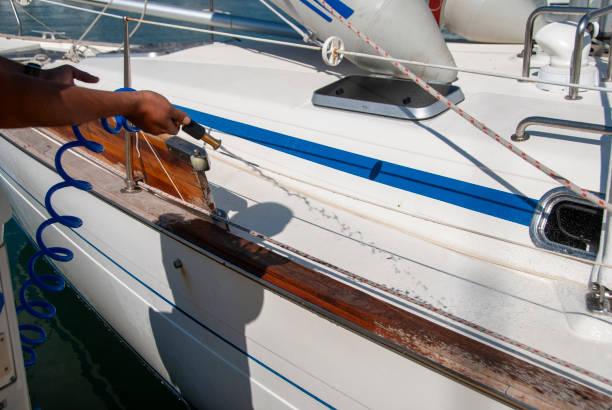 istock Man washing white boat with pressure water system at pier 2195629886