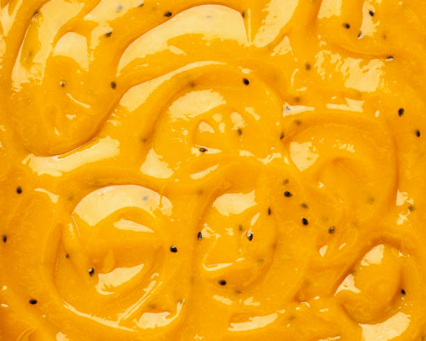 istock Passionfruit and mango jam texture with swirls and pulp in a close up on the surface. Bakery dessert concept. Full frame delicious background. 2195631839