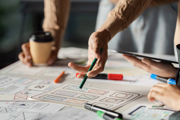 istock Creative UX/UI Design Brainstorming Session with Designers Collaborating on Wireframes and Prototypes 2195632759