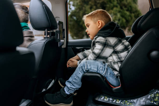 istock Boy using digital tablet while sitting at child's seat in car 2195632974