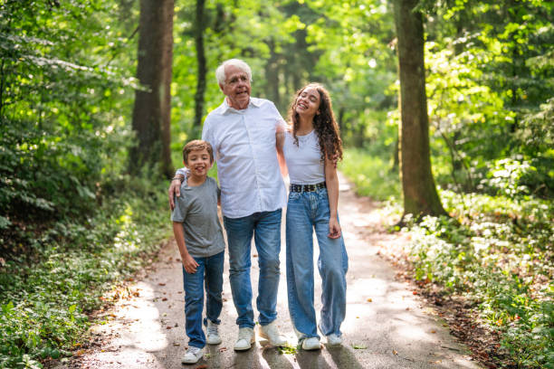 A father walking in the park with his daughter and son
