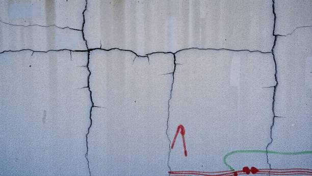 istock Cracked concrete wall texture with paint splatters. 2195634975