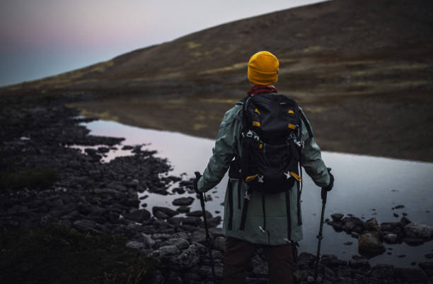 istock Hiker in warm clothing exploring a serene mountain lake at twilight 2195639800