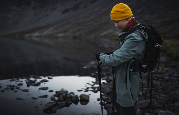 istock A hiker dressed warmly uses smart watch for navigation while observing lake surroundings during a mountainous outdoor adventure, underlining the beauty and tranquility of nature. 2195639946