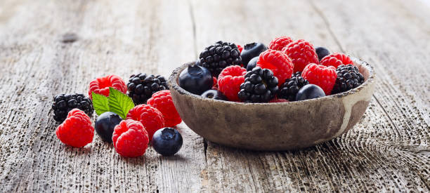 istock Fresh berries on old wooden board 2195641085
