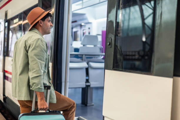 istock Young tourist boarding a train with his suitcase 2195643067