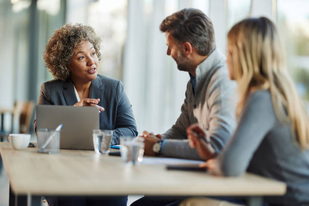 istock Female insurance agent talking to her customers in the office. 2195644363