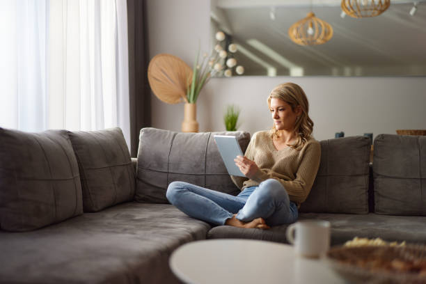 istock Relaxed woman surfing the Internet on touchpad at home. 2195645540