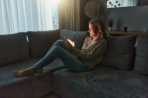 istock Relaxed woman text messaging on smart phone at home. 2195645843