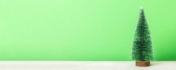 istock One small Christmas tree on colored background. new year decoration with copy space 2195649388