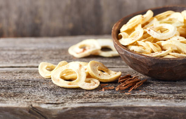 istock Apple chips with cinnamon powder on wooden background 2195651199