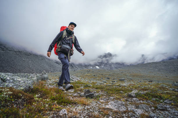 istock Solo Hiker Exploring Rugged Mountain Terrain Under Overcast Skies 2195654219