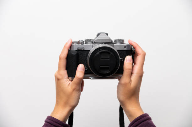 istock Hand holding classic retro style camera in modern assembly, on white background, front view, retro updated things concept 2195657267