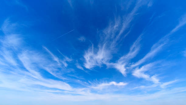 istock blue sky with white clouds and aircraft trails 2195657535