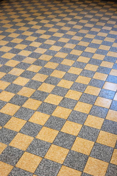 istock Square black and orange mosaic tile floor inside building. Top view, vanishing perspective, no people 2195658458