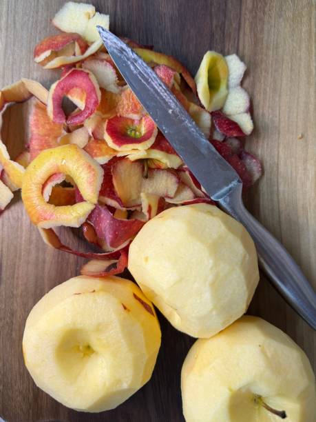 istock Hands peeling a cooking apple on a wooden board. 2195659919
