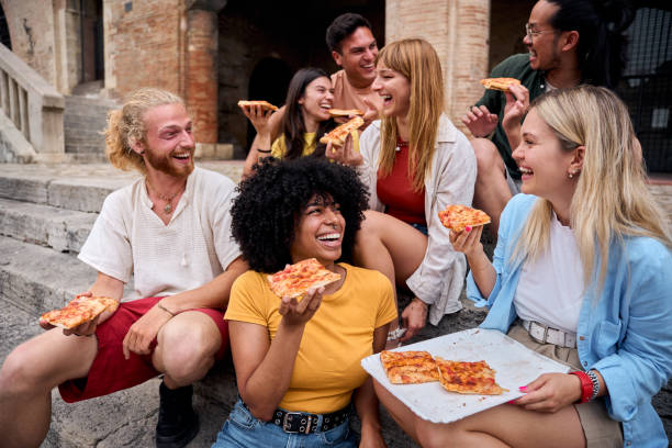 istock Happy multi-ethnic friends eating pizza outdoors in urban setting 2195661218