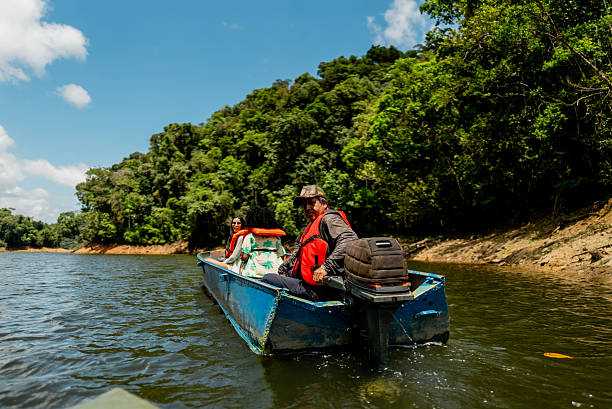 A Klotok (traditional wooden riverboat) navigating up the Sekonyer River in Tanjung Puting National Park. This is a popular rout for tours to visit the  orangutans in their natural habitat, along with other wildlife and the lush rainforest, Central Kalimantan, Borneo, Indonesia.
