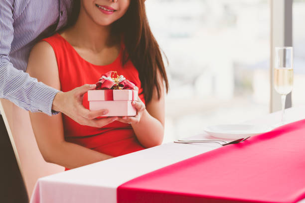istock Happy love couple with gift box enjoying spending time together in dinner 2195664938
