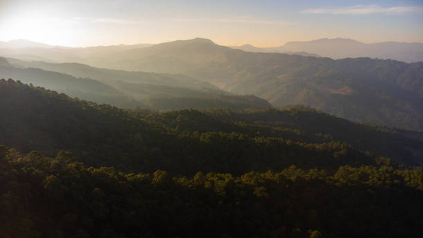 istock Beautiful sunset in the winter mountains. The setting sun shines down on a serene mountain landscape covered with tropical trees in the evening. 2195665298