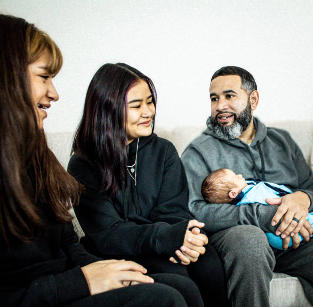 istock Hispanic father sits on couch with his children 2195667177