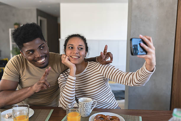 istock Happy couple taking a selfie while enjoying breakfast together at home, capturing a joyful and candid moment in a modern, cozy dining area 2195668068