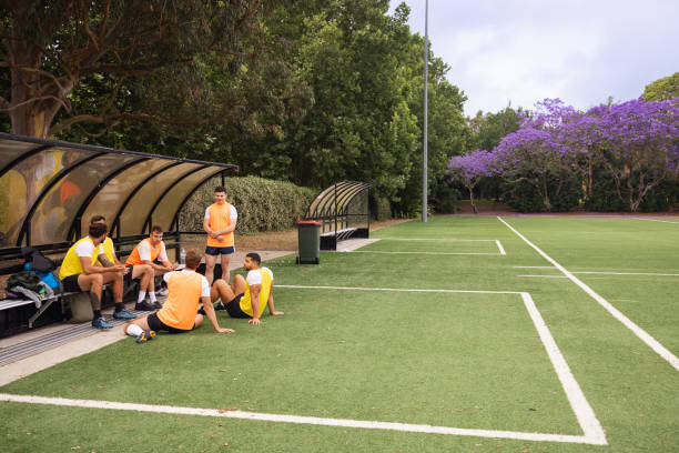 istock Football Team Taking a Break on Field Side Substitutes Benches 2195669035