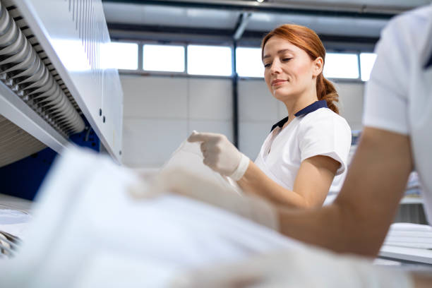 istock Dry cleaning business. Preparing clean laundry for ironing. 2195669109