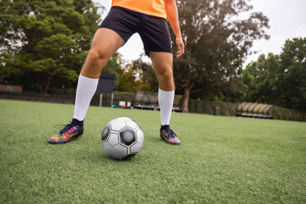 istock Football Player Practicing on Grass Field with Ball in Natural Setting 2195669749