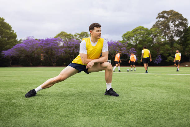 istock Athlete Performing Dynamic Stretches Before Football Training on Green Field 2195672634