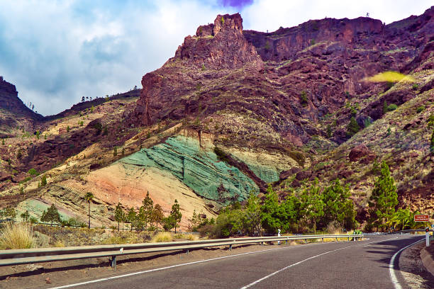 Fuente de los Azulejos in winter. The Monumento Natural Azulejos de Veneguera is a unique and one-of-a-kind basalt formation with amazing colors that can only be found here on Gran Canaria. During the day, the rocks shine in a natural turquoise and ochre color play. In the background you can still see the Montaña de Tauro mountain range.