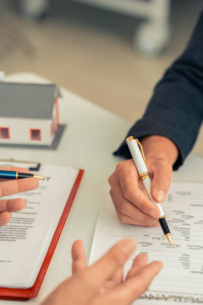 istock Real Estate Purchase Advisory Office Brokers help business partners make financial investments. Mortgage installments, bank loan concept. Vertical format. 2195675013
