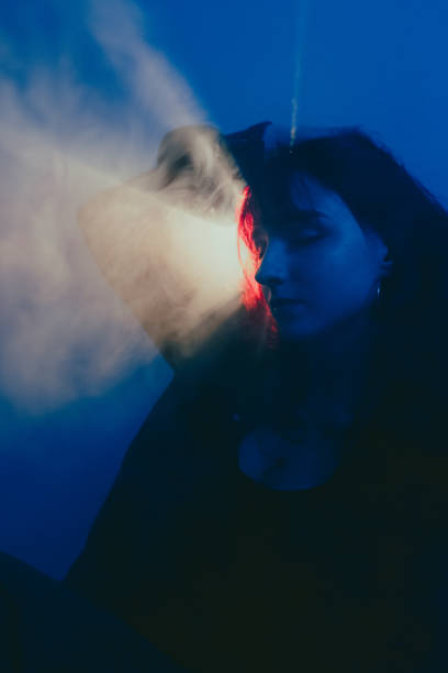 istock Woman breathing smoke in atmospheric lighting 2195675722