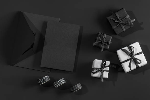 istock White and black gift boxes on a black background and a black envelope with space for text. 2195681780