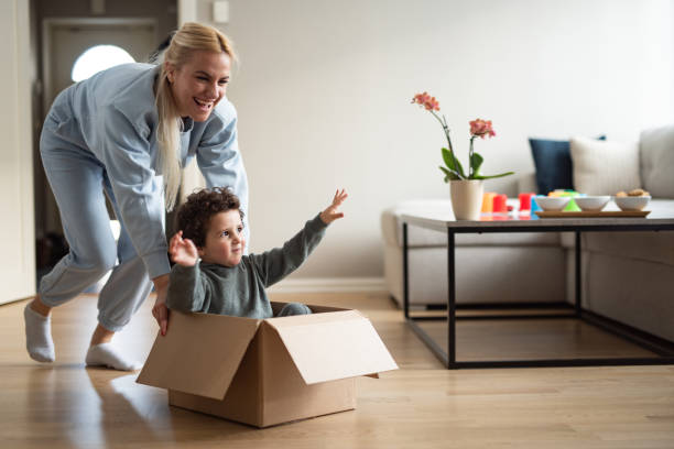 istock Mother is playing with her son in living room. 2195684267