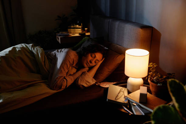 istock Woman Napping with Lit Lamp 2195686984