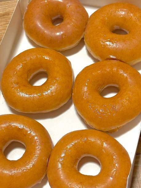 istock A classic glazed donut with a soft, fluffy texture and a sweet, glossy coating. Perfectly balanced between light and sugary, making it an irresistible treat for any time of the day. 2195687363