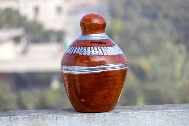 A clay bank, used for saving money, displayed on a wall, with a blurred nature background.