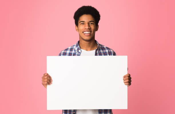 istock Happy guy showing blank placard with copy space for your text 2195690599