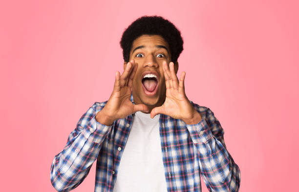 istock Attention. Guy shouting, holding hands near mouth 2195690636